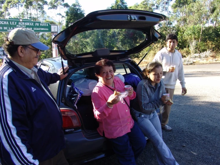 a group of people standing around an open hatchback