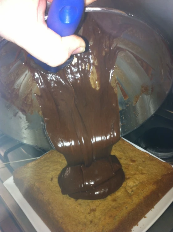 a chocolate cake being prepared for cooking and being frosted