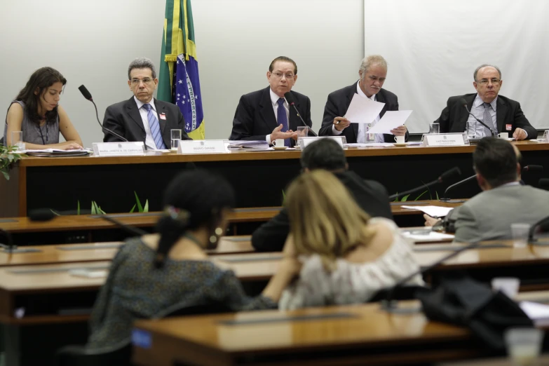 several people sitting at a conference with microphones