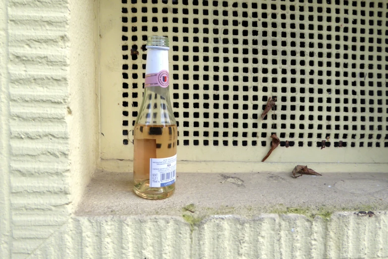 a bottle on the ground near a wall