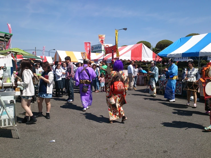 many people are walking around with various colored tents behind them