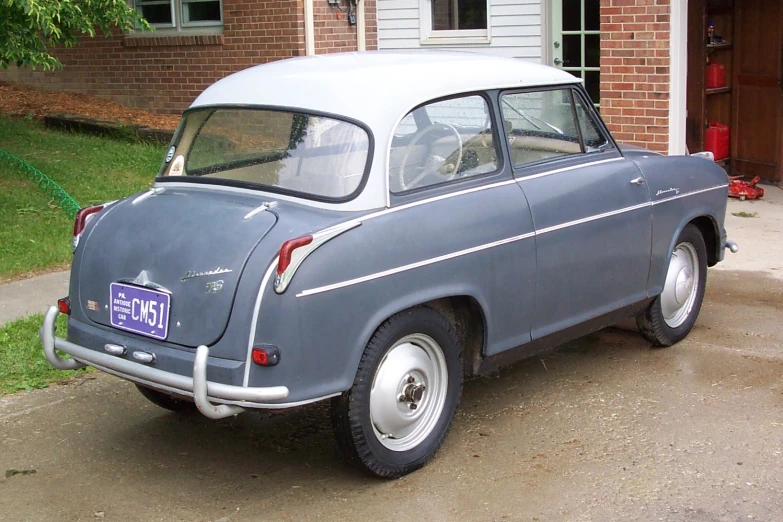 an old car sits parked in front of a house