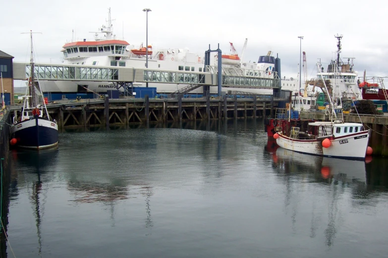 some large ships docked in a harbor with one boat still on the water