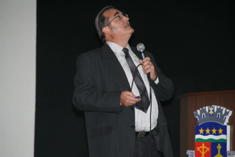 man wearing business suit speaking into a microphone