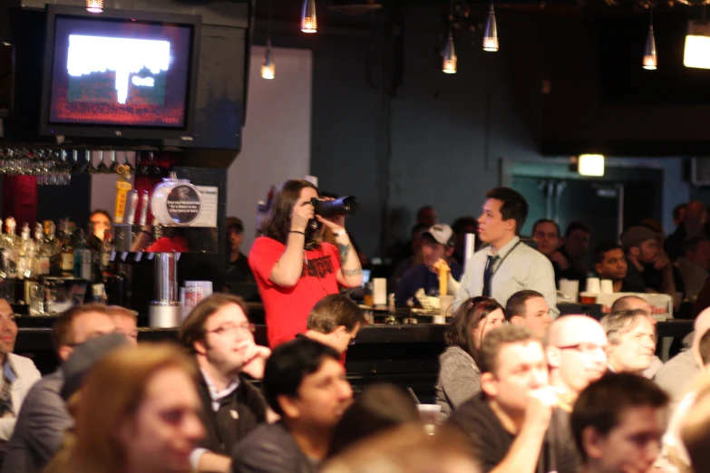 a woman singing into a microphone at a bar