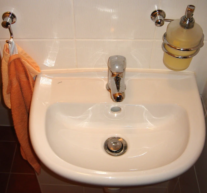 a white sink that is sitting under a mirror