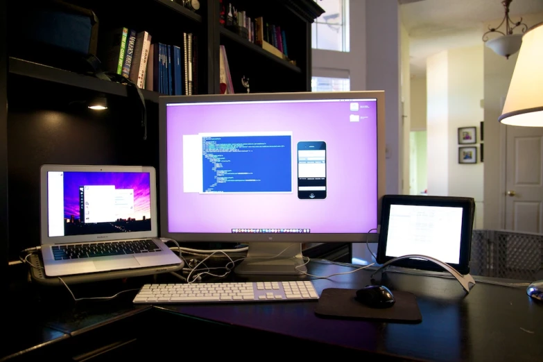 computer monitors on top of a black table