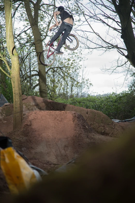 a man on a bike jumps off a small hill