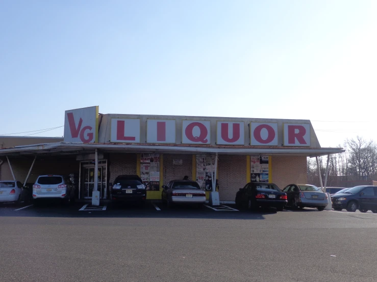 a liquor store with multiple cars parked in front of it