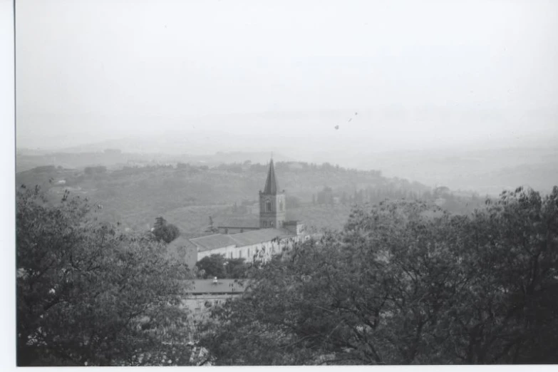 a church is seen through a foggy mountain