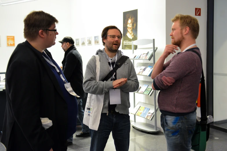 three men standing in an area with white walls