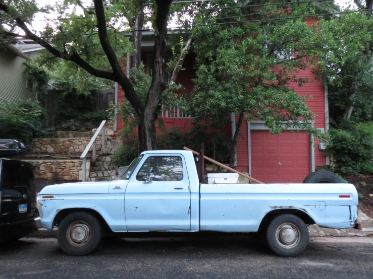 a light blue truck parked next to a building