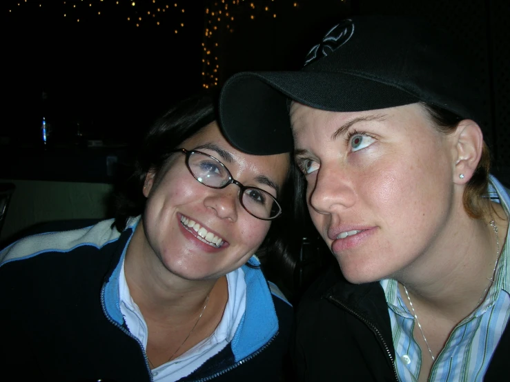 two women pose for a po in a dark room