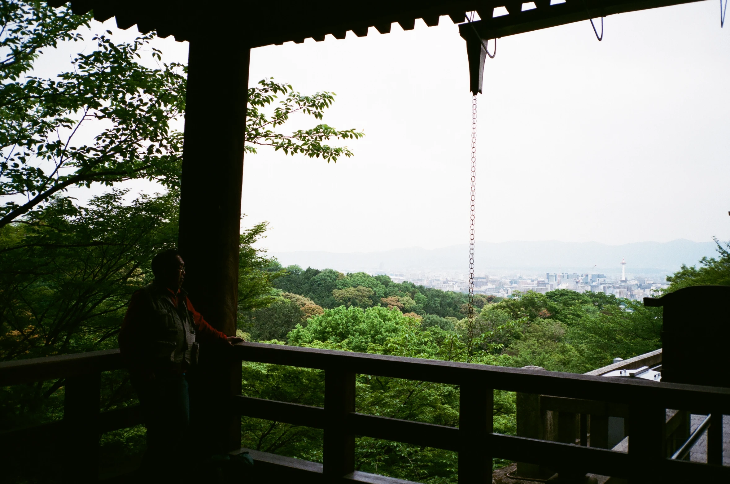 two people sitting in an open gazebo overlooking a valley