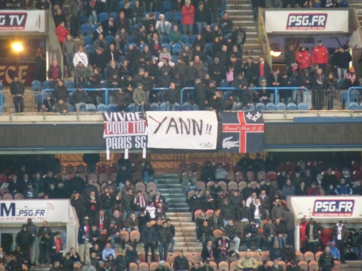 some fans in the stands with some banners on their backs