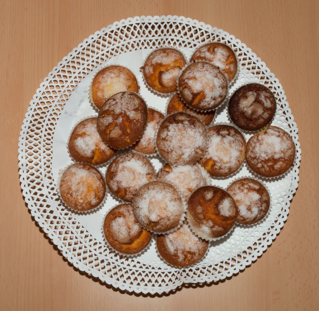 powdered pastry on a white plate and wooden table