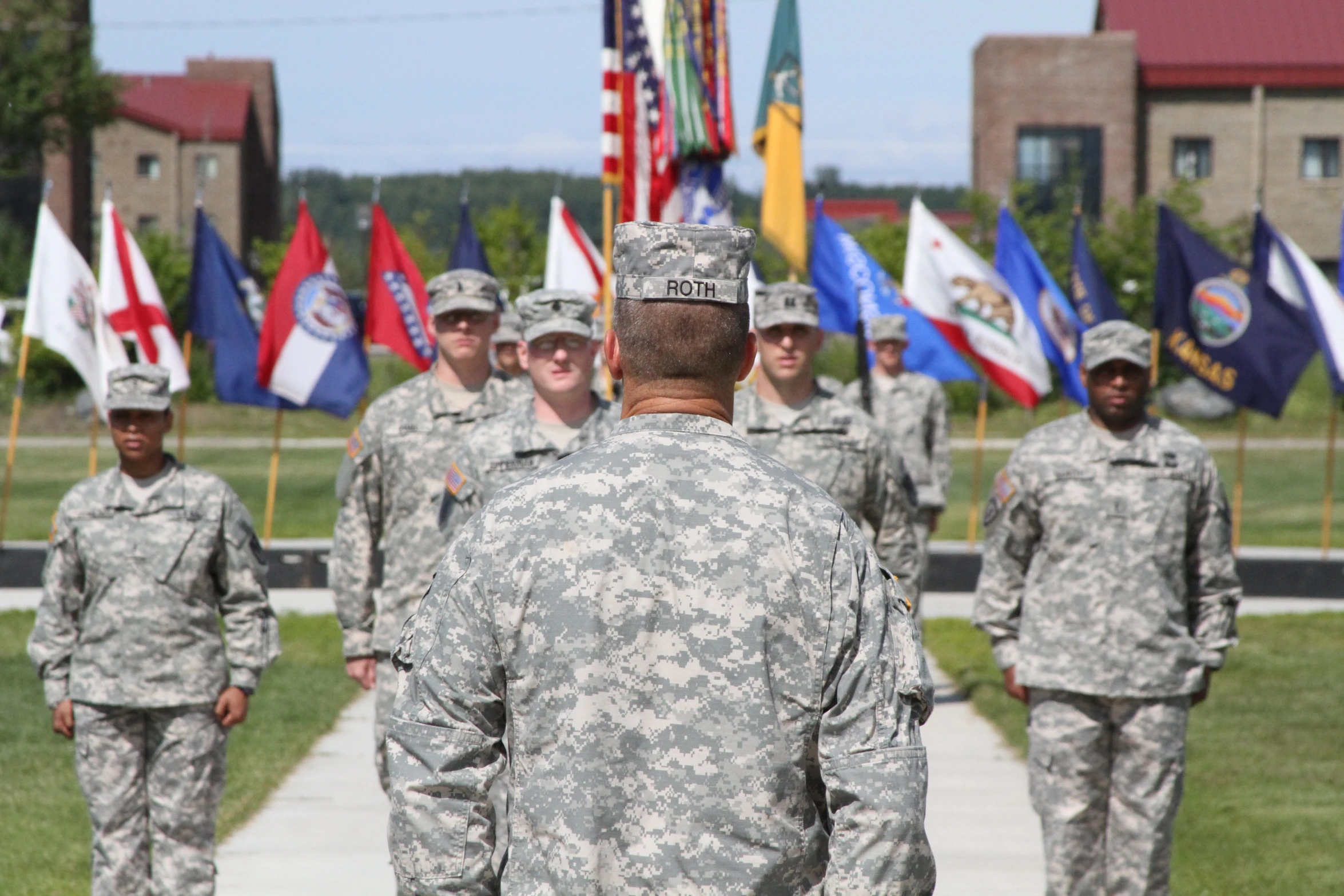 men in uniforms in front of american flags