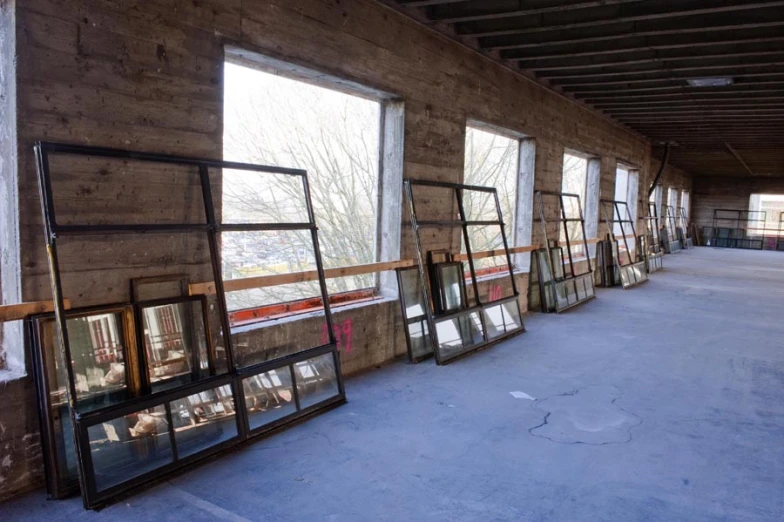 several framed pictures stand in front of windows inside of a building
