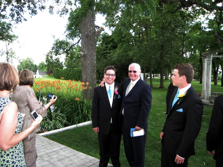 a group of men in suits are standing around talking