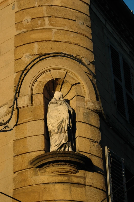 a statue is mounted on the side of a tall building