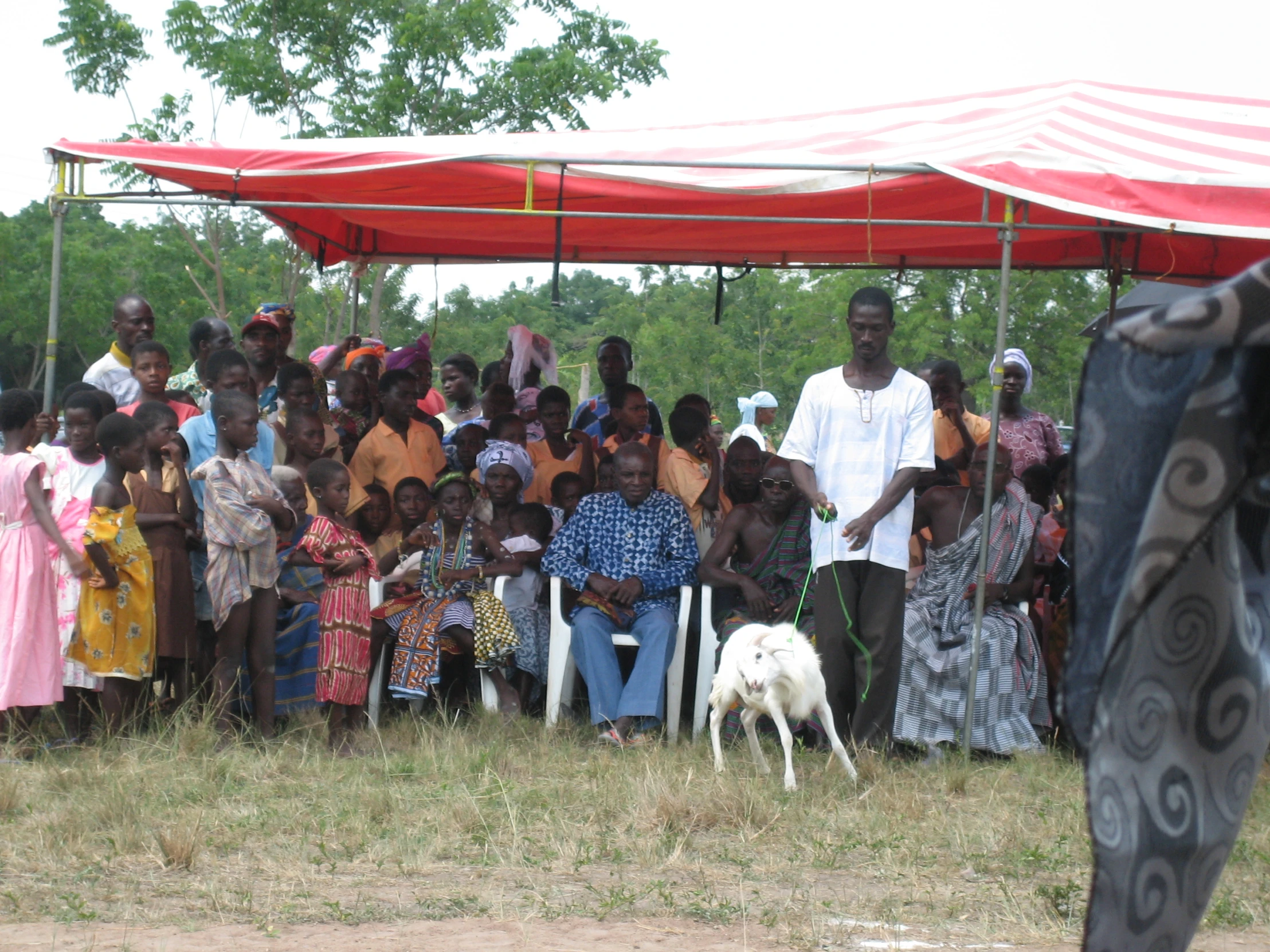 a group of people are under a tent on the ground