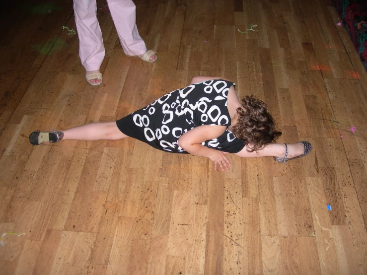 a young lady lays on the ground with her arm around her body