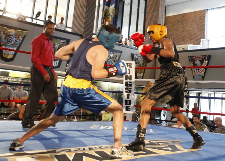 two men in boxing gear kick at a opponent