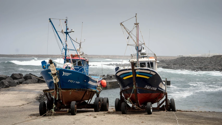 two blue and red boats next to each other at the water