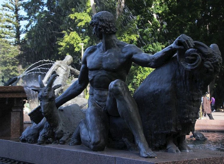 there is a sculpture depicting a man with three bulls