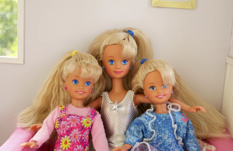 the three dolls are posed next to each other