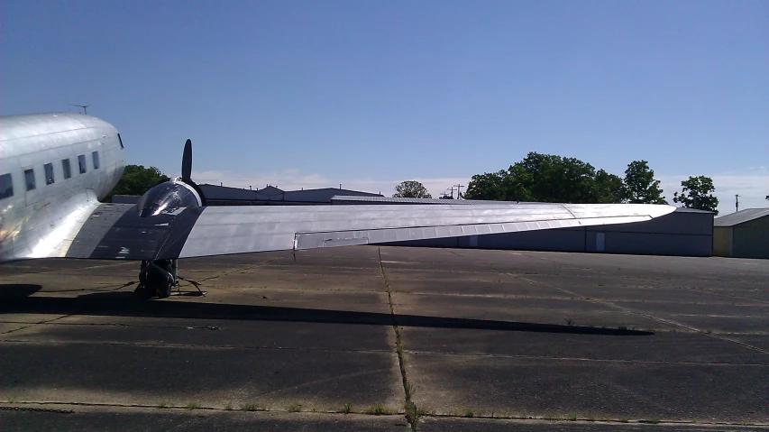 a plane sitting on an airport tarmac next to some houses