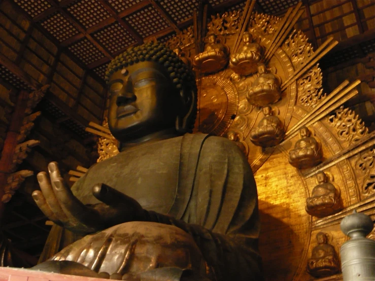 a buddha statue with many carvings on the wall