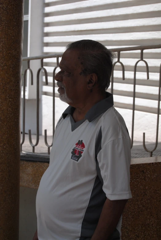 a man is standing near an iron fence