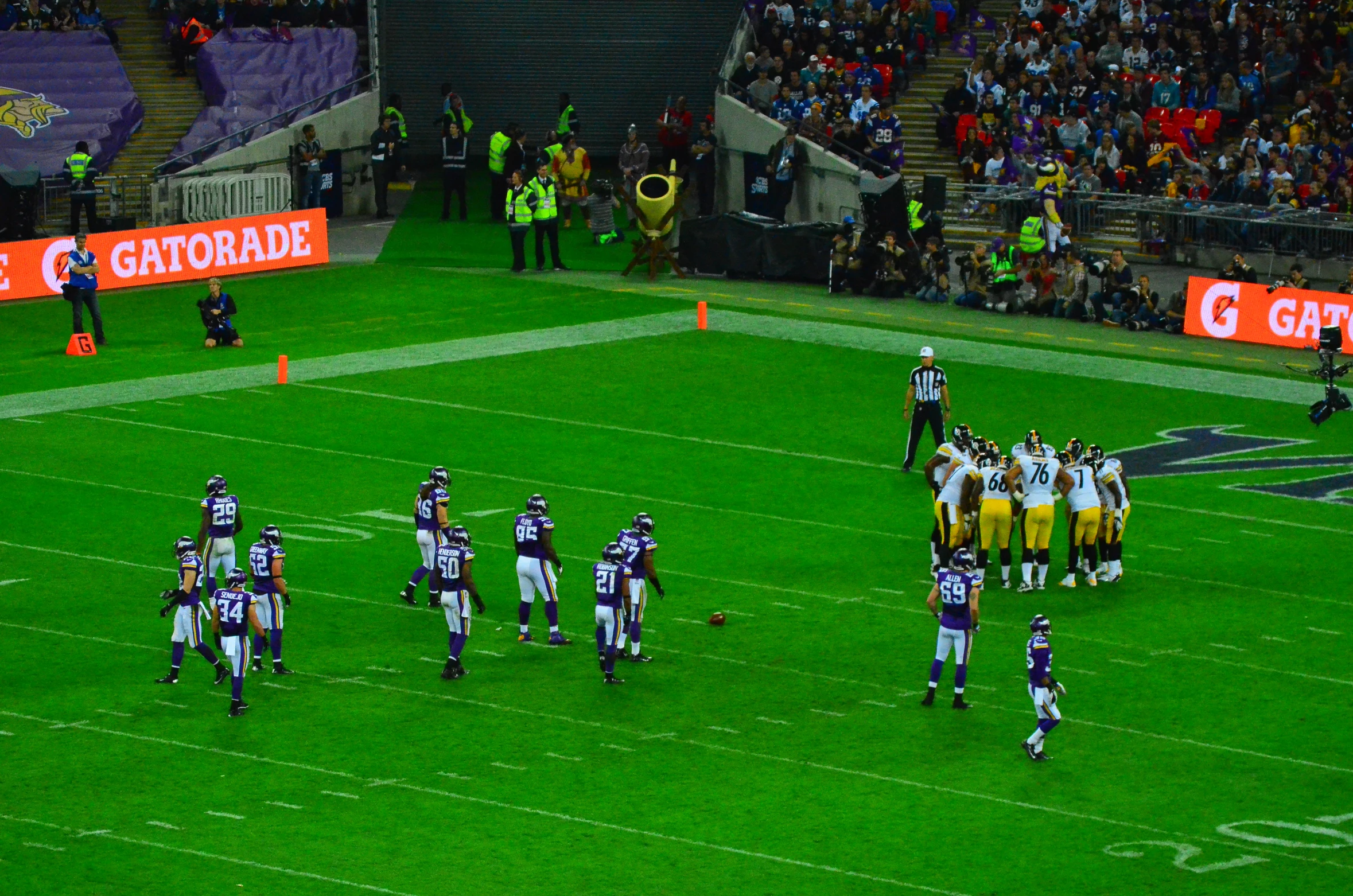 a group of people playing a game of football on a grass field