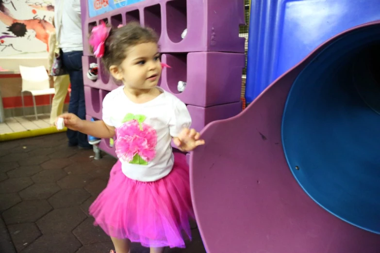 an adorable little girl standing by some large pink pieces