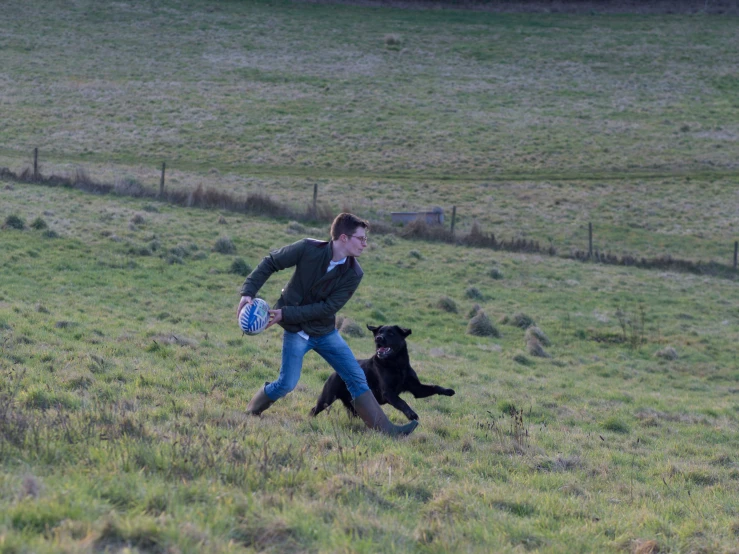 the man with the gloves is playing with his dog