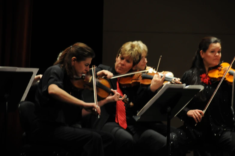 two men and one woman are playing the violin together