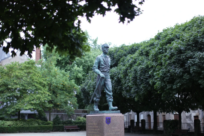 a statue of a man standing in front of some trees