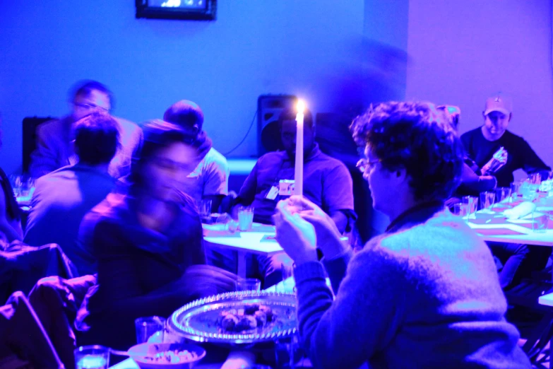 a group of people sitting around a table with pizza