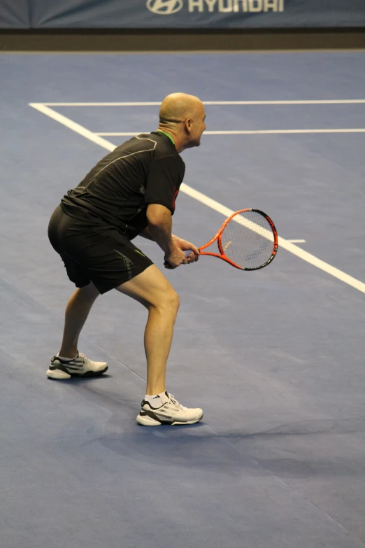 a man standing on a tennis court holding a tennis racquet