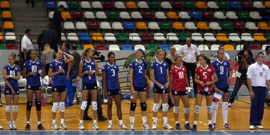 volleyball players lined up on the court before a match