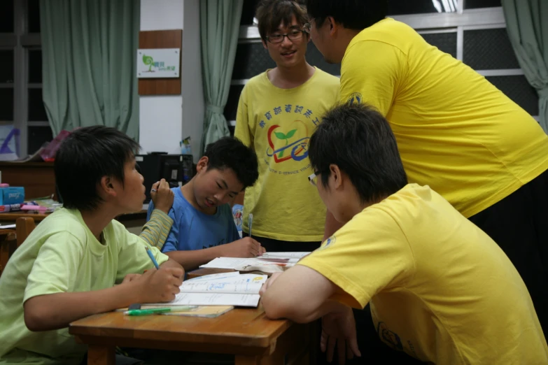 the group of children is learning how to use a laptop