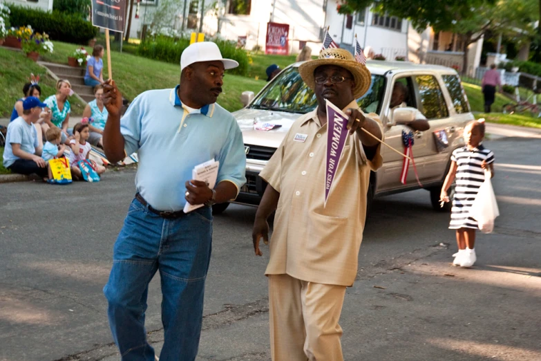 a man holding soing up next to another man in the street