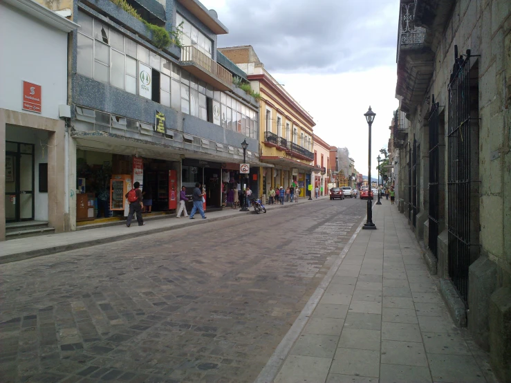 pedestrians walk on an empty city street in the afternoon