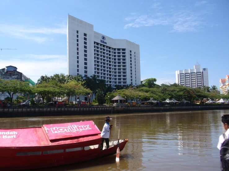 a woman is standing on the boat in the water