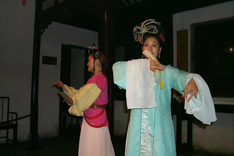 a couple of women dressed in chinese attire holding items