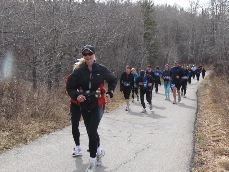 group of people jogging uphill on path during daytime