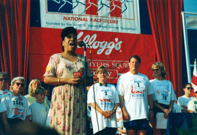 a woman in floral dress standing next to an american flag