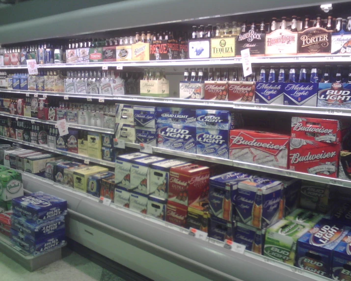 an aisle with shelves and bins of beverages