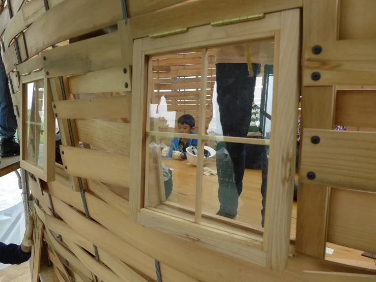 people in the reflection of several wooden windows